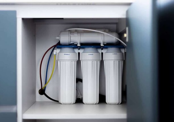 Under-sink water filter system with multiple filtration stages for clean drinking water.